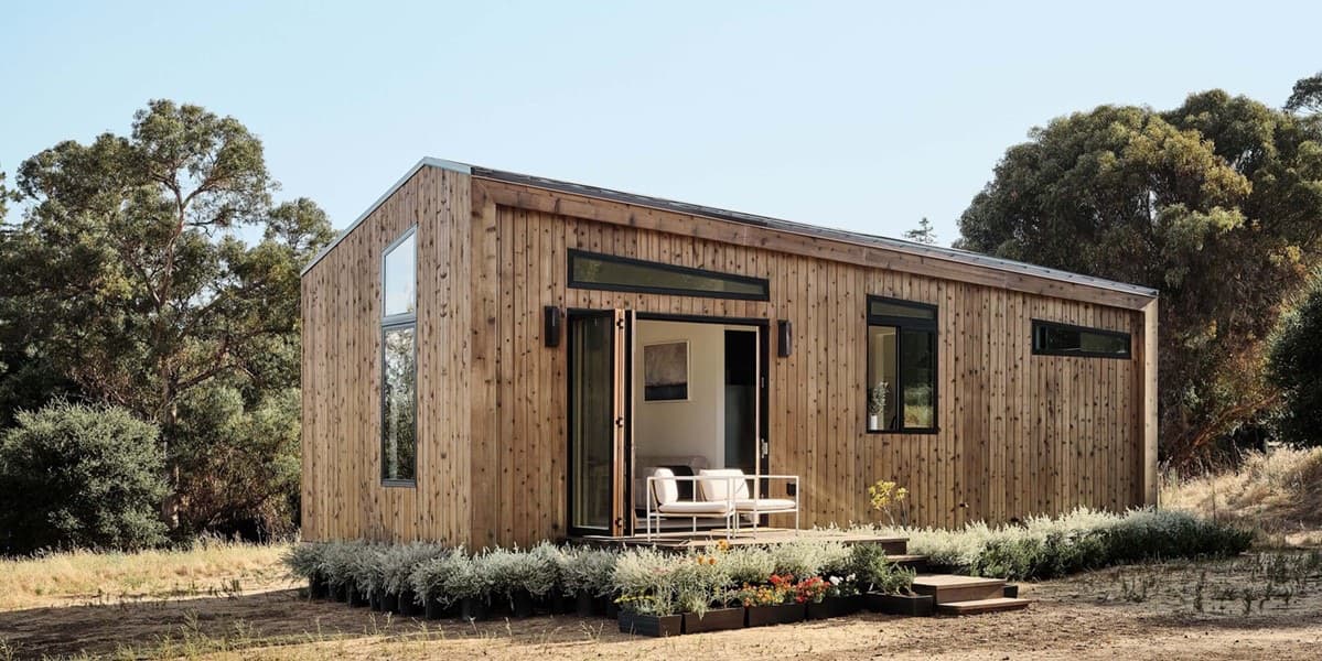 An Abodu Studio backyard home with vertical wood siding and a sliding glass door